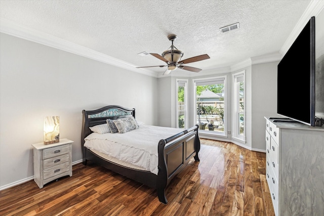 bedroom with crown molding, visible vents, baseboards, and wood finished floors