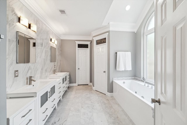 full bath featuring a sink, double vanity, ornamental molding, visible vents, and a garden tub