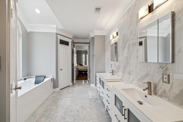 ensuite bathroom with visible vents, a bath, a sink, ornamental molding, and double vanity