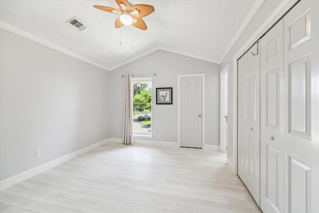 unfurnished bedroom with visible vents, baseboards, a closet, light wood-type flooring, and vaulted ceiling