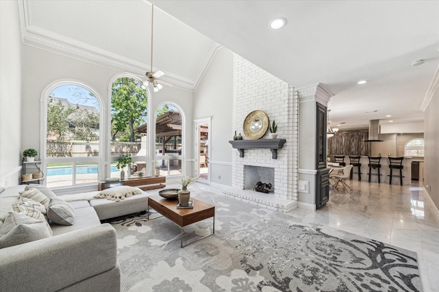living area featuring a healthy amount of sunlight, marble finish floor, a brick fireplace, and high vaulted ceiling