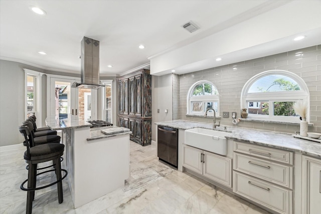 kitchen with dishwashing machine, visible vents, a center island, island exhaust hood, and a sink
