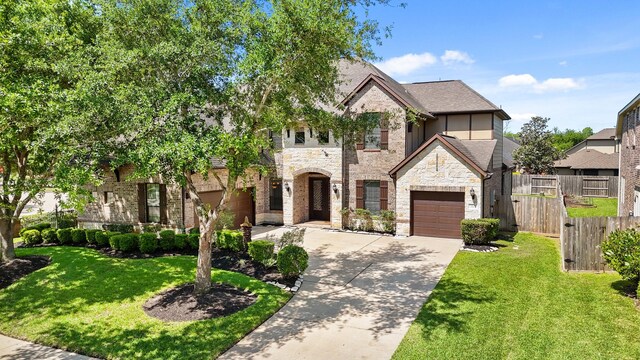 3203 Round Meadow Ln, Missouri City, TX 77459 - french country home with driveway, stone siding, a front yard, a garage, and fence