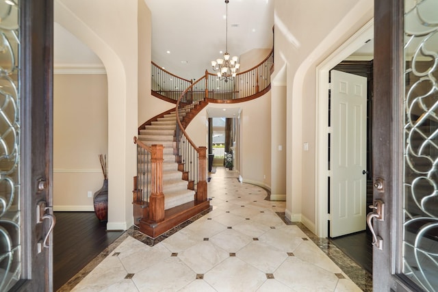 3203 Round Meadow Ln, Missouri City, TX 77459 - entrance foyer featuring a towering ceiling, baseboards, an inviting chandelier, stairway, and arched walkways