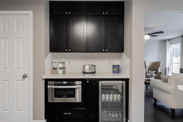 bar featuring beverage cooler, backsplash, and a ceiling fan