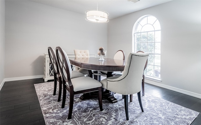 dining area with healthy amount of natural light, baseboards, and dark wood-type flooring