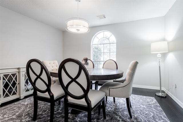 dining room with baseboards and dark wood-type flooring