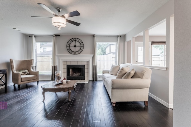 living room featuring a ceiling fan, plenty of natural light, dark wood finished floors, and baseboards