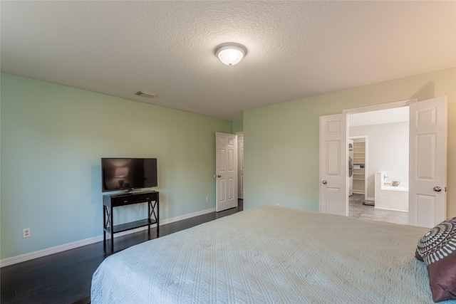 bedroom with baseboards, wood finished floors, and a textured ceiling