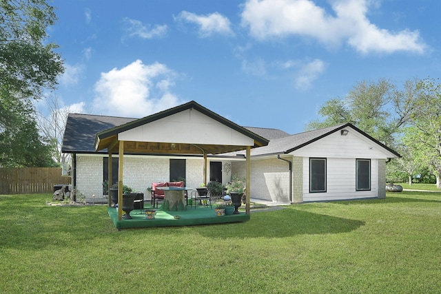 back of house featuring a gazebo, brick siding, fence, and a lawn