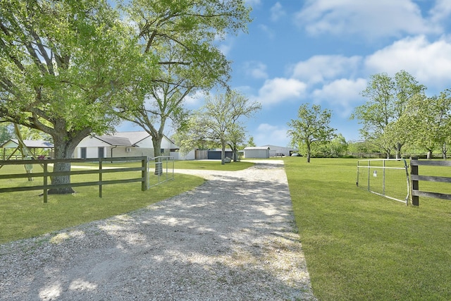 view of property's community featuring driveway, fence, and a lawn