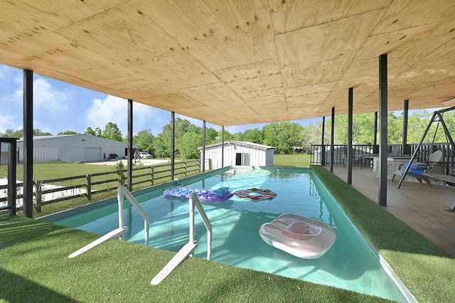 view of community featuring a yard, a shed, and an outdoor structure