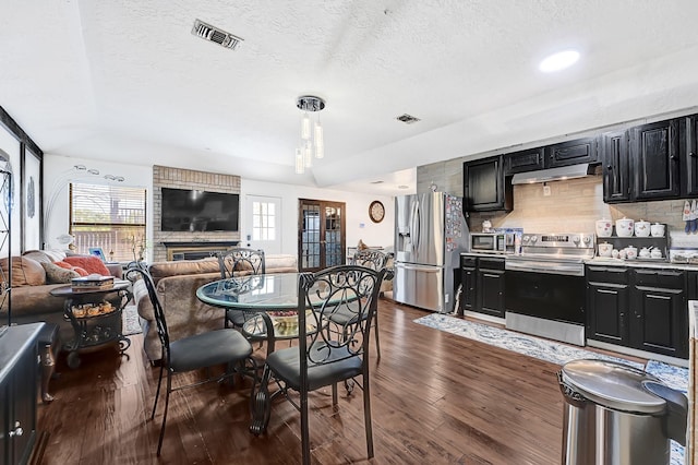 dining space with visible vents, dark wood finished floors, and plenty of natural light