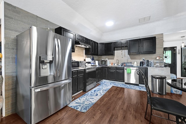 kitchen featuring visible vents, light countertops, dark wood-style floors, under cabinet range hood, and stainless steel appliances