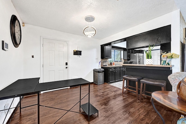 interior space with a notable chandelier, a textured ceiling, and wood finished floors