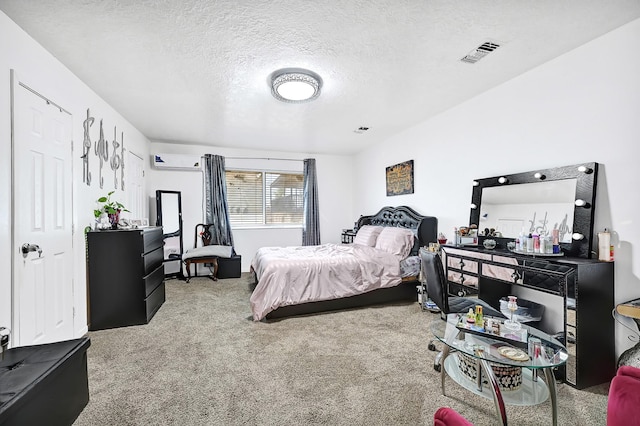 carpeted bedroom featuring a textured ceiling, a wall unit AC, and visible vents