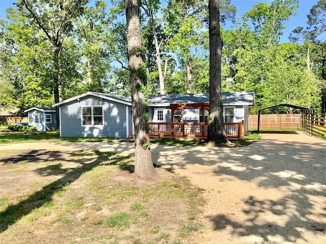 view of front of house featuring a carport, fence, a deck, and driveway