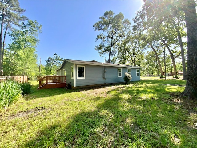 back of house featuring a yard, fence, and a wooden deck