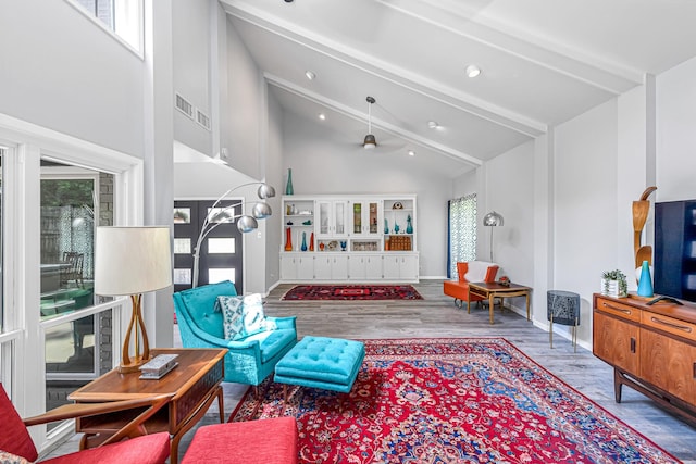 living room with a ceiling fan, beam ceiling, wood finished floors, baseboards, and high vaulted ceiling