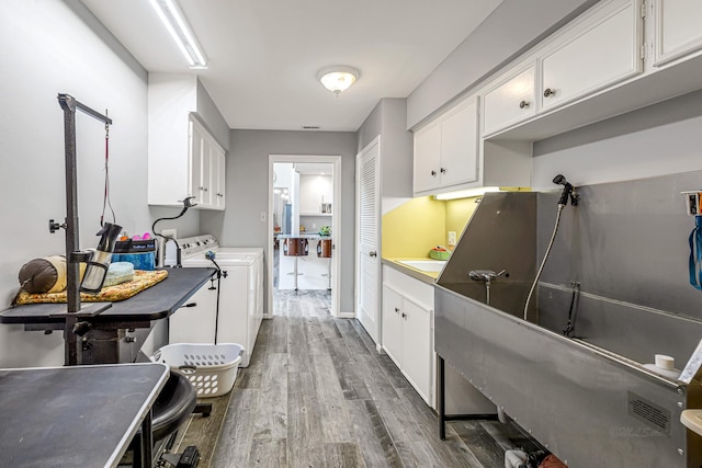kitchen with washer / clothes dryer, white cabinets, visible vents, and dark wood-style floors