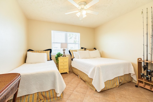 bedroom featuring ceiling fan, light tile patterned flooring, and a textured ceiling