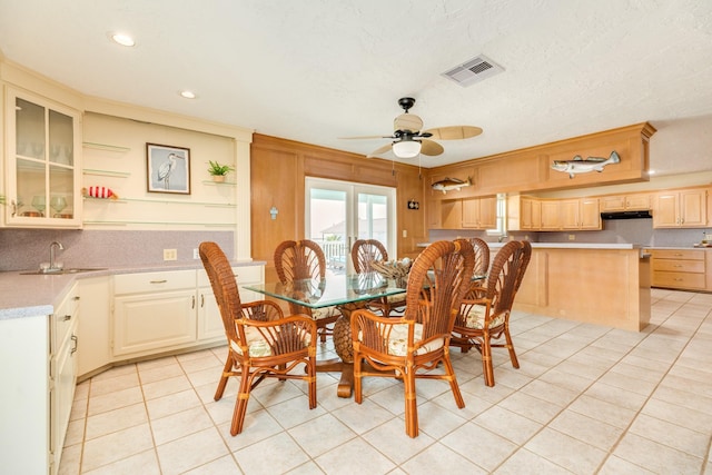 dining room with light tile patterned floors, visible vents, crown molding, and ceiling fan