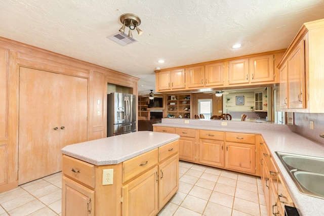 kitchen featuring stainless steel refrigerator with ice dispenser, light tile patterned floors, visible vents, and light brown cabinets