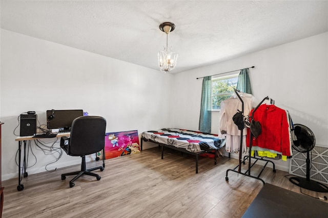 bedroom with a chandelier and wood finished floors