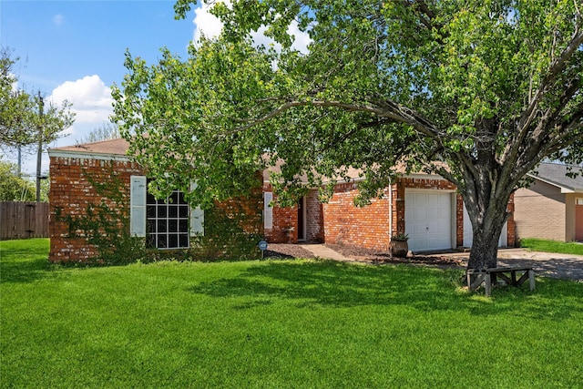 obstructed view of property with an attached garage, concrete driveway, a front yard, and brick siding