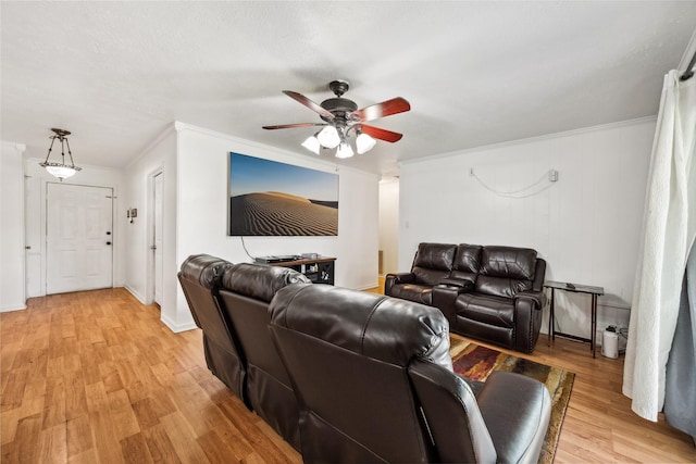 living room with light wood-style floors, crown molding, and a ceiling fan