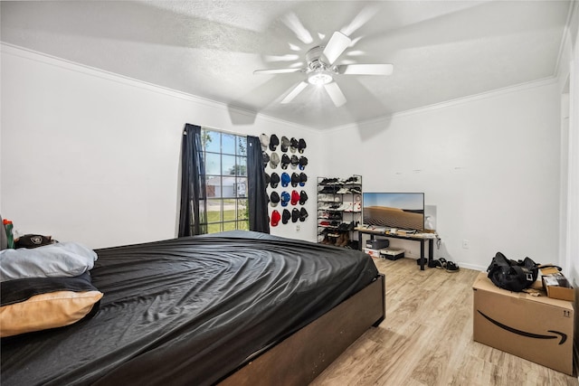 bedroom with light wood-style flooring, ornamental molding, and a ceiling fan