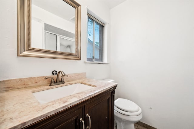 full bath with a shower stall, vanity, and toilet
