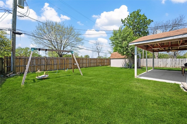 view of yard featuring a patio, a fenced backyard, and a playground