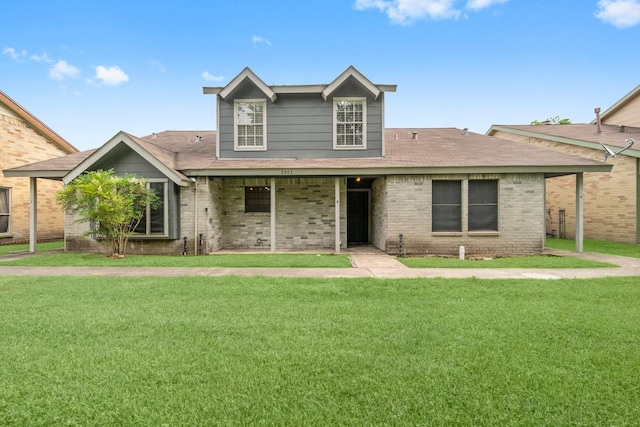 traditional-style house with brick siding, a front yard, and roof with shingles