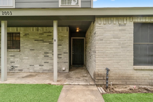 property entrance featuring brick siding