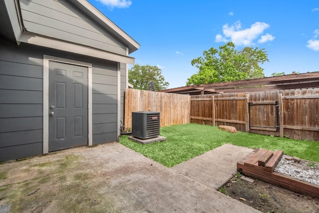 view of yard with a patio, a gate, central AC unit, and a fenced backyard