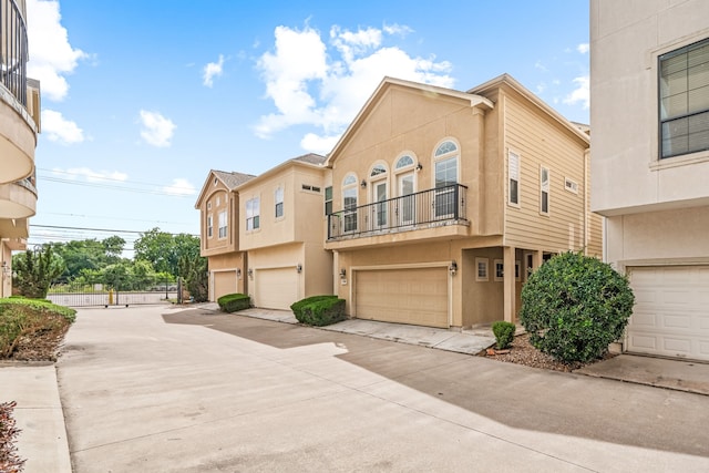 multi unit property with concrete driveway, a balcony, and stucco siding
