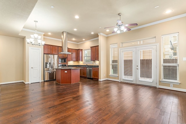 kitchen featuring stainless steel appliances, dark countertops, island range hood, ceiling fan with notable chandelier, and a kitchen island