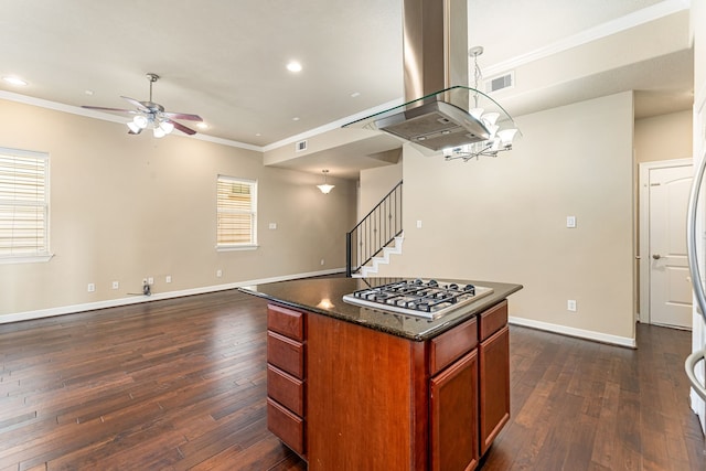 kitchen featuring ceiling fan, island range hood, crown molding, stainless steel gas cooktop, and dark wood-style flooring