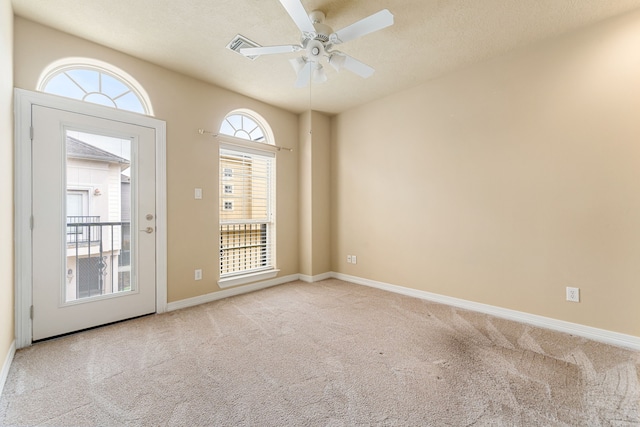 unfurnished room with carpet floors, visible vents, baseboards, and ceiling fan