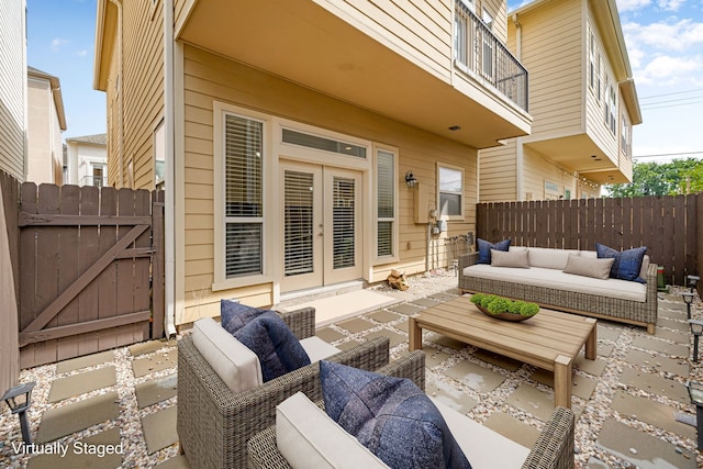 view of patio with a gate, outdoor lounge area, fence, and french doors