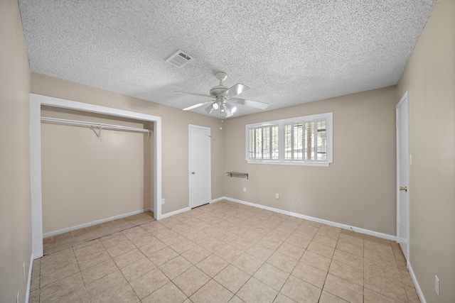 unfurnished bedroom featuring ceiling fan, baseboards, visible vents, a textured ceiling, and light tile patterned flooring