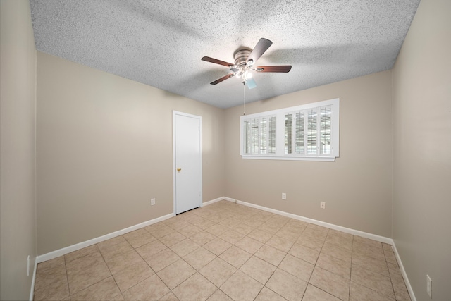 unfurnished room with baseboards, ceiling fan, a textured ceiling, and light tile patterned flooring