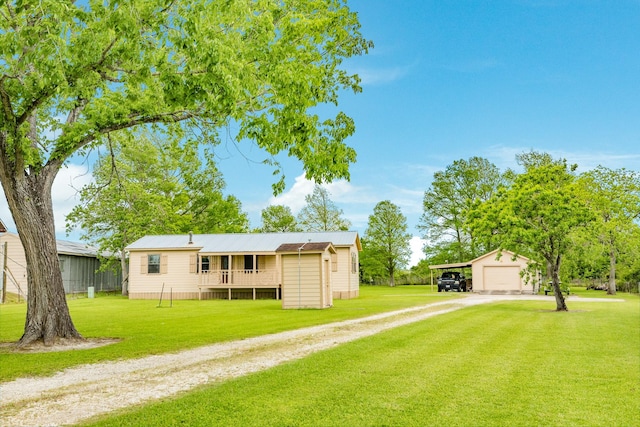 back of house with driveway, a yard, and a garage