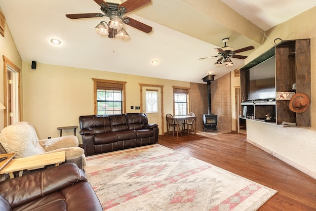 living area featuring recessed lighting, lofted ceiling, wood finished floors, a wood stove, and ceiling fan