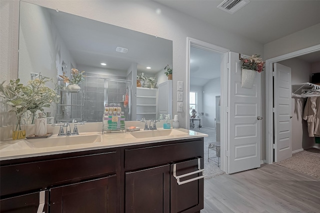 bathroom with double vanity, visible vents, a sink, and a stall shower