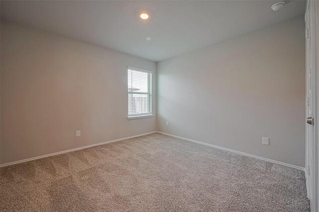 carpeted spare room featuring baseboards