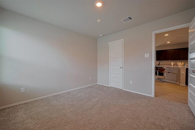 unfurnished bedroom featuring recessed lighting, visible vents, light colored carpet, and baseboards