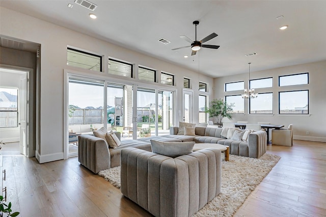 7606 Redwoods Forest Dr, Katy, TX 77493 - living area with light wood-style floors, ceiling fan with notable chandelier, and visible vents