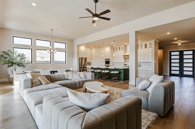 7606 Redwoods Forest Dr, Katy, TX 77493 - living room with visible vents, light wood finished floors, recessed lighting, and ceiling fan with notable chandelier